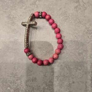 Beautiful pink beaded elastic bracelet with rhinestone cross detail.